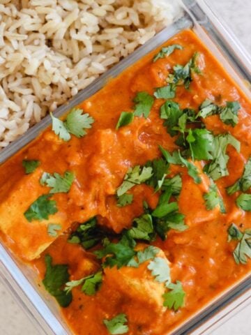 Vegetarian meal prep tofu curry with rice in a glass container.