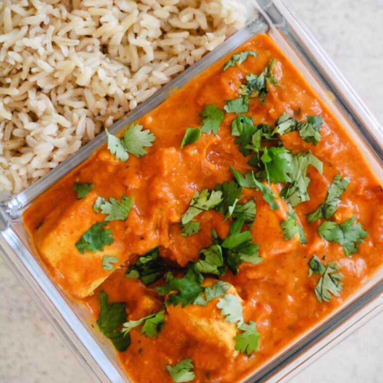 Vegetarian meal prep tofu curry with rice in a glass container.