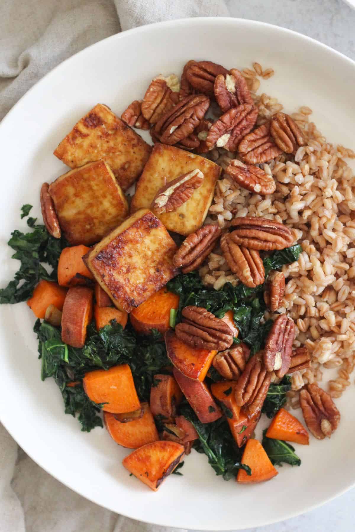 Tofu and sweet potato bowl with farro and pecans.