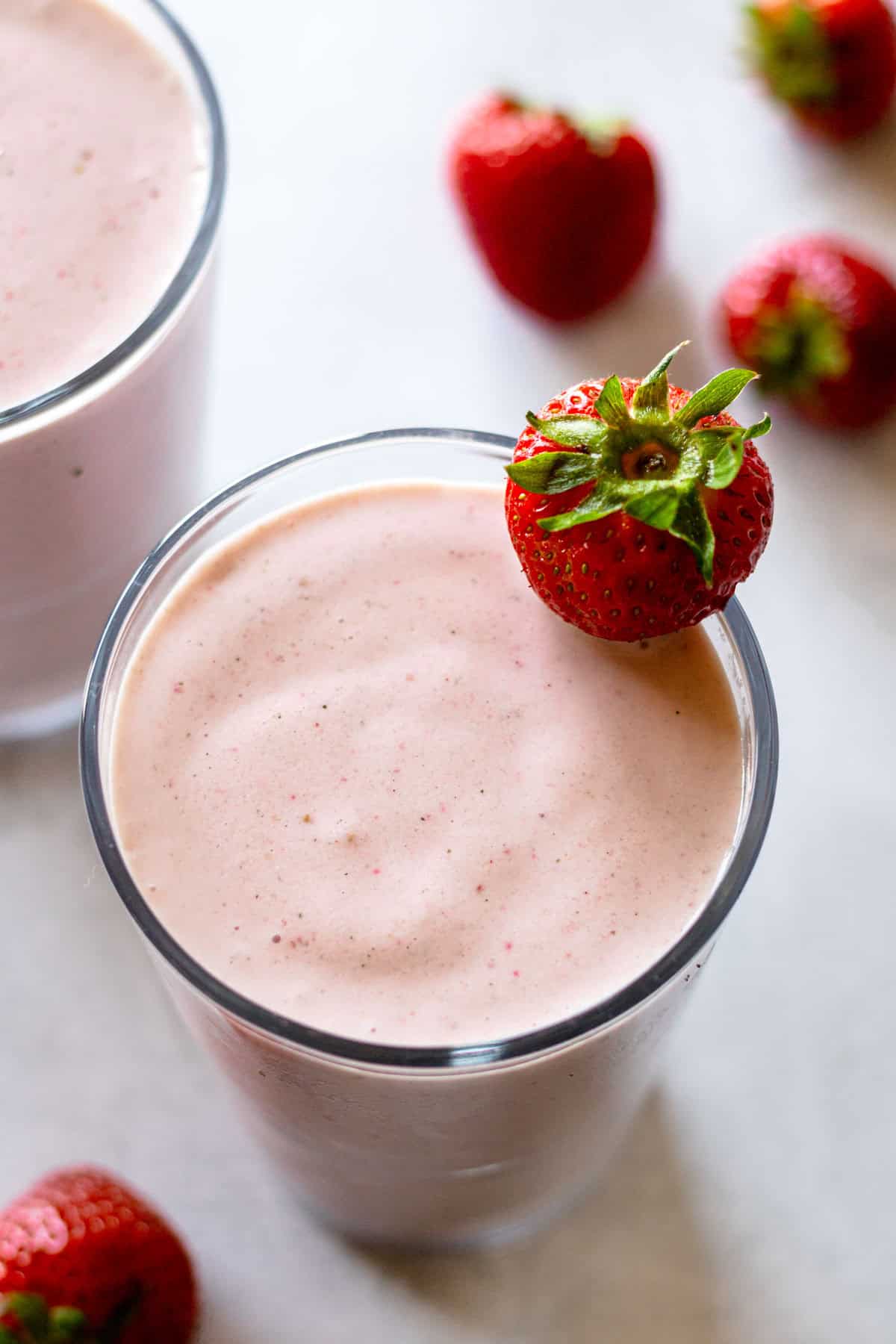 Strawberry banana smoothies garnished with fresh strawberries.