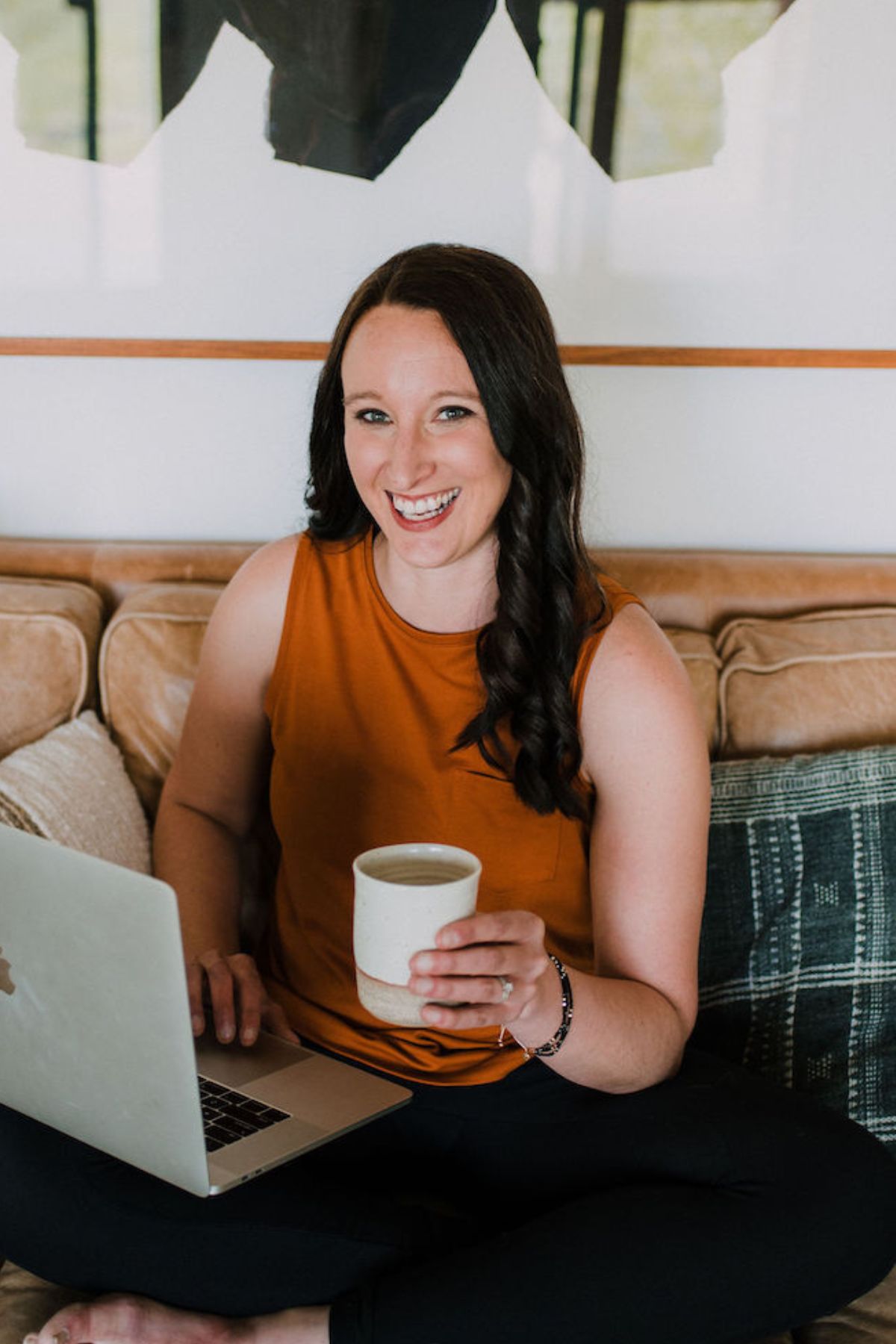 Image of registered dietitian and intuitive eating counselor, Stephanie McKercher, smiling with her laptop and a mug.