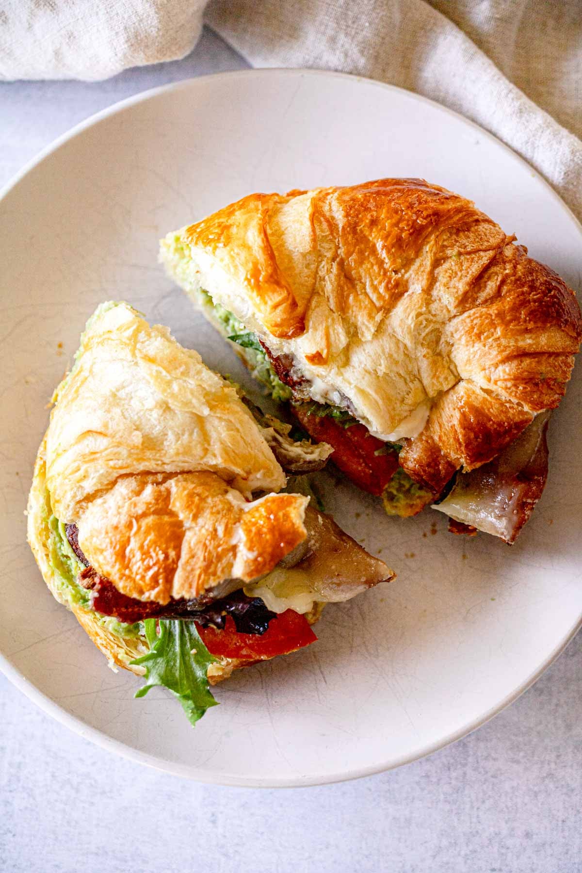 Bacon Avocado Croissant Sandwich with Swiss cheese.
