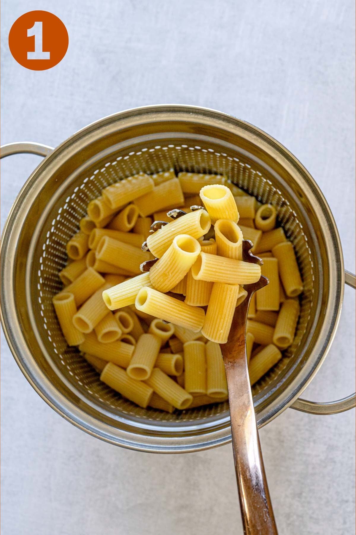 Cooked rigatoni drained in colander, labeled "1."