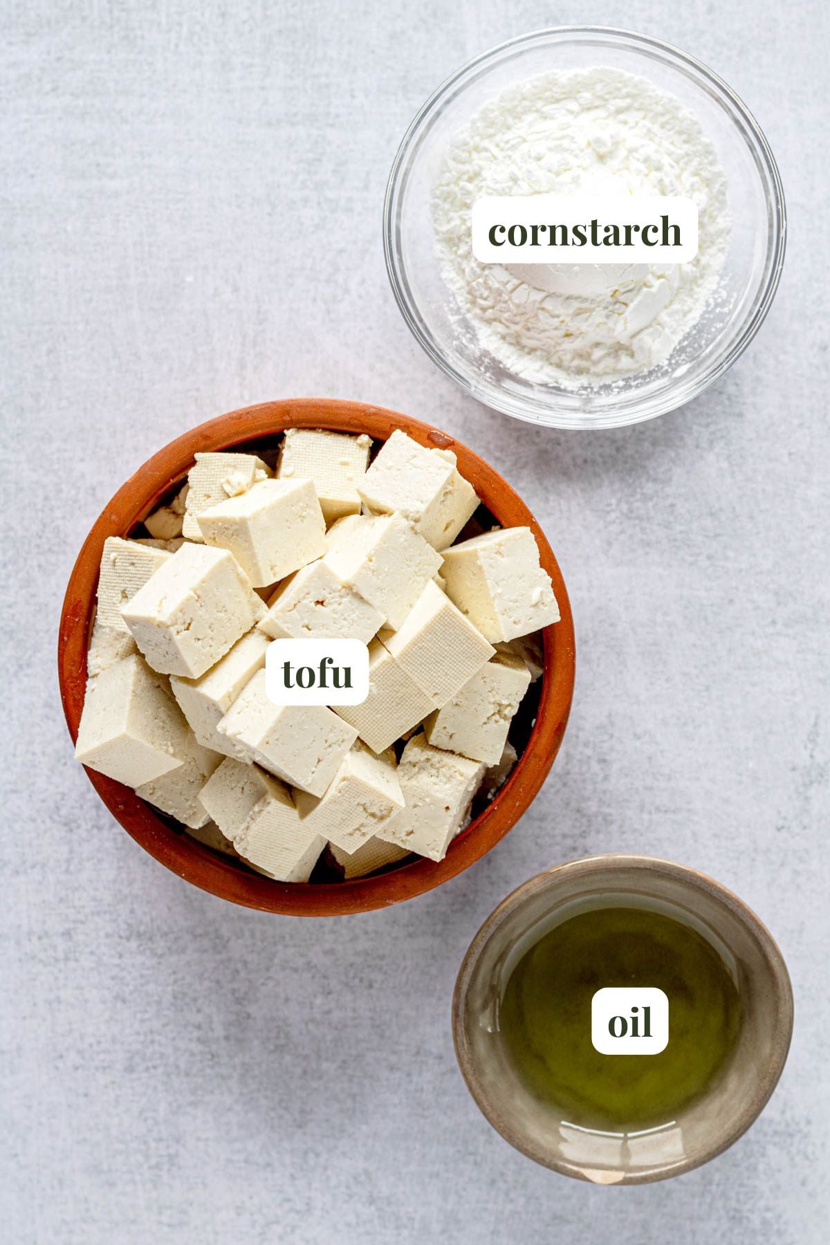Labeled ingredients (tofu, cornstarch, and oil) to make air fryer crispy tofu.