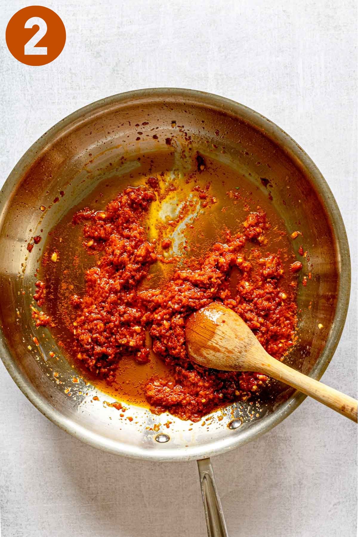 Thai red curry paste cooking in a skillet; labeled 2.