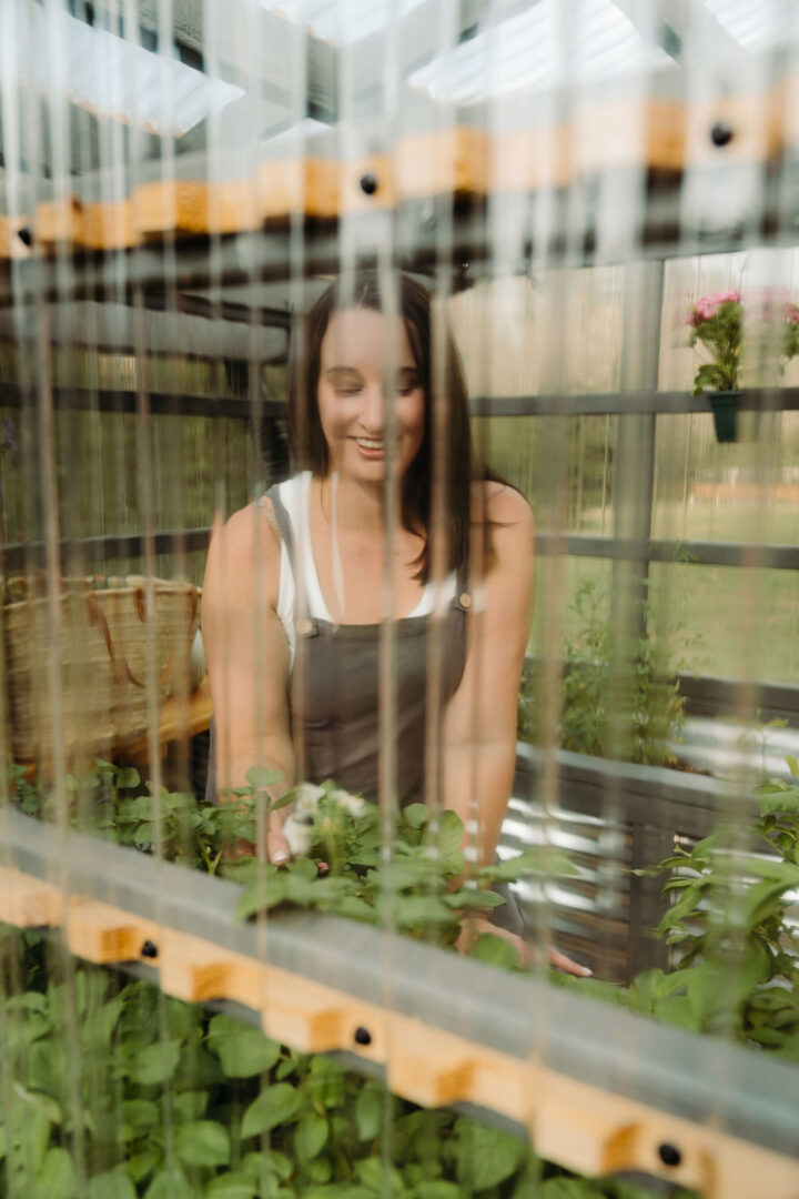 Stephanie McKercher gardening in her greenhouse