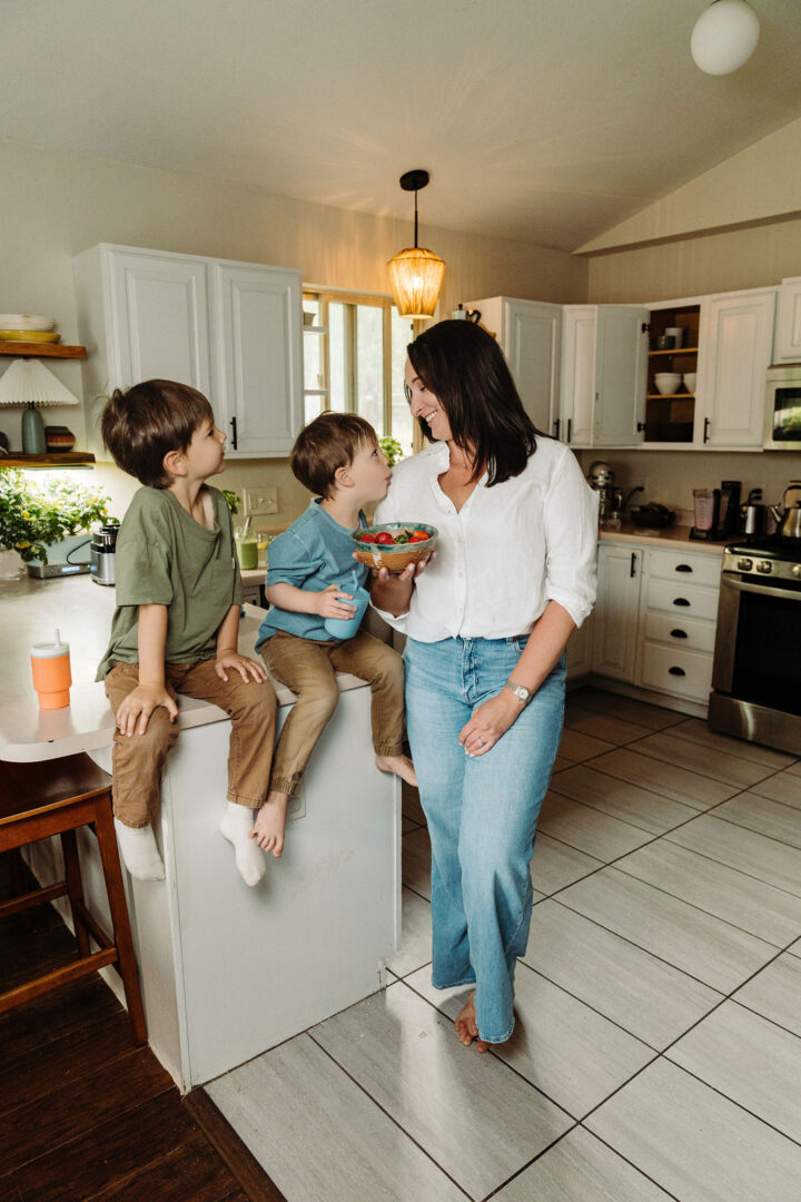 Stephanie McKercher eating strawberries with her two sons in her Colorado mountain kitchen.